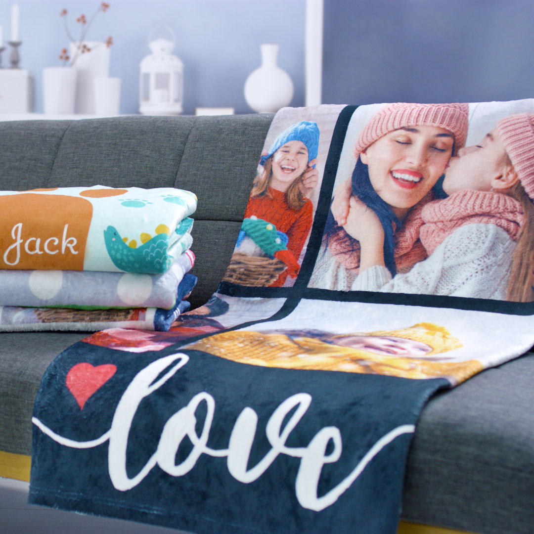 Mother sitting on the bed with her two little children convering two cushions with new photo cushion covers with family photos.